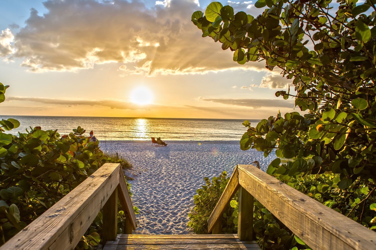 Boardwalk leading to sunset on beach