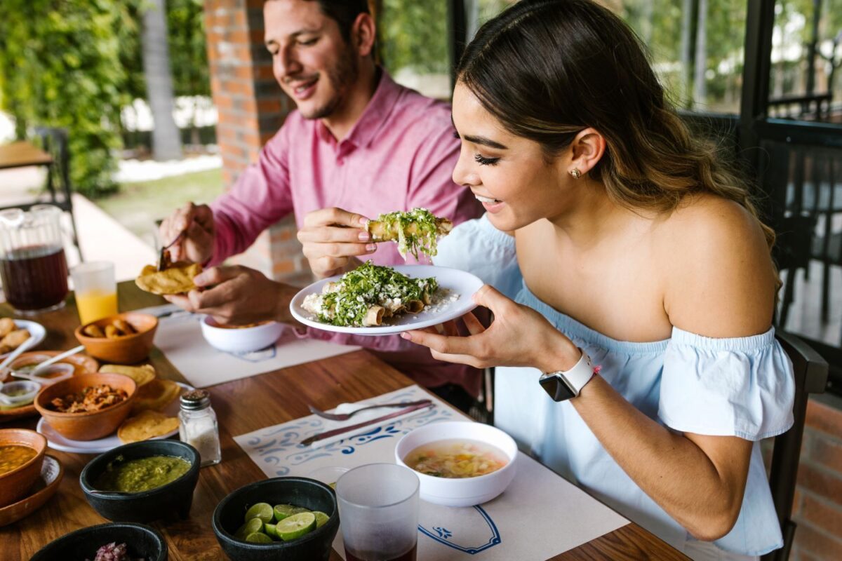 couple sharing a colorful display of Mexican food